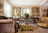 Vergoldeter Spiegel im Wohnzimmer mit gepolstertem Sessel und Hocker in einem Haus in Kent, England, UK
