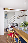 Kitchen table with view to stairs and wall-mounted paddle in Dartmouth home, Devon, UK