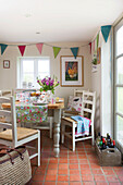 Wine crate in terracotta tiled kitchen with bunting in High Halden farmhouse Kent England UK