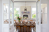 Dining table and chairs viewed through double doors in Kilndown home Cranbrook Kent England UK