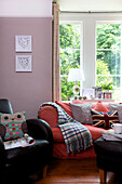 Eulenkissen auf schwarzem Ledersessel mit Sofa am Fenster im Wohnzimmer von Staplehurst, Kent, England, UK