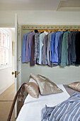 Shirts hang on individual hooks in bedroom of Staplehurst home Kent England UK