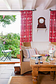 Zweisitziges Rohrsofa an der Terrassentür von Worth Matravers Cottage in Dorset, England, UK