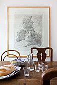 Wooden table and chairs with wall map in kitchen of Emsworth beach house Hampshire England UK