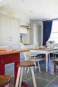 Painted white chair at table in open plan kitchen of Woodchurch home Kent England UK