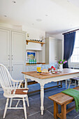 Painted white chair at table in open plan kitchen of Woodchurch home Kent England UK