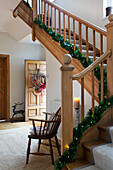 Christmas decorations with fairylights on wooden banister in Faversham entrance hallway Kent England UK