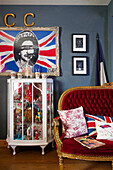 Gesammelte Vintage-Objekte in einem Schrank mit Pop-Art und Sofa in einem Haus in Tenterden, Kent, Großbritannien