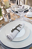 Antler napkin holder on plate with crystal glassware on dining table in London home UK