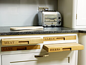 Chopping board storage with stainless steel toaster in kitchen detail of Nottinghamshire home England UK