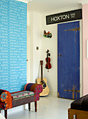 Gepolsterte Sitzbank mit geborgenen Schildern und Saiteninstrumenten in einem Familienhaus in London, UK