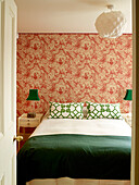 Blick durch die Tür zum Schlafzimmer mit grünen Akzentfarben, Vintage-Tapete und Papierschirm, Stadthaus in London, UK