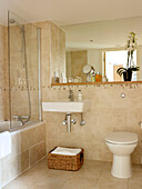 Basket below washbasin with recessed mirror shelving in Ipswich warehouse conversion, Suffolk, England, UK