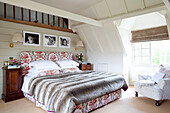 Pelzdecke auf einem Bett mit Blumenmuster in einem Cottage mit Holzrahmen in Kent, England, UK
