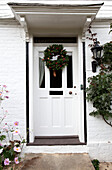 Christmas wreath on white front door of Kent home, England, UK