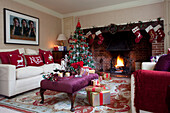 Weihnachtsgeschenke und Getränke auf einem Hocker mit festlicher Dekoration in einem Haus in Kent, England, UK