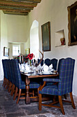 Blue tartan dining chairs at set table in Scottish home UK