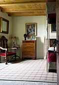 Carved chair and wooden chest of drawers in bedroom of Scottish home UK