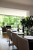 Dining table with flower arrangement in contemporary London home, England, UK