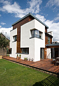 Lawned exterior of newbuild with wood cladding, London, England, UK