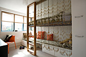 Kinderzimmer mit Perlenvorhang über erhöhtem Pritschenbett in einem Londoner Familienhaus, England, UK