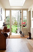 Dog sits at open back door to Epsom garden Surrey UK