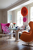 Glass topped dining table and Ghost chairs at sash windows in dining room