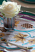 White rose and silverware of floral tablecloth in Cotswolds home UK