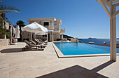 Sunloungers at poolside in luxury holiday villa, Republic of Turkey