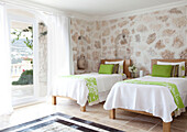 Twin bedroom with lime green soft furnishings in holiday villa, Republic of Turkey