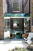 Home extension with brick wall and glass ceiling in contemporary London townhouse, UK