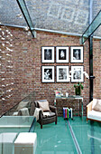 Home extension with brick wall and glass ceiling and floors in contemporary London townhouse, UK