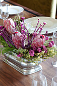 Pink flower arrangement on wooden dining table of Suffolk home UK