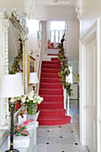 Pink carpeted hallway with Christmas garlands in London home UK