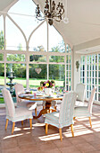 Tisch für sechs Personen in einem Wintergarten mit hohem Dach in einem klassischen Haus in Berkshire, England, Vereinigtes Königreich