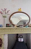 Ovaler Spiegel auf dem Kaminsims eines Hauses in Rye, East Sussex, England, UK