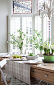 Schnittblumen und Geschirr am Fenster eines Hauses in Surrey, England, Vereinigtes Königreich