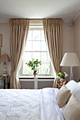 Cut lilies on bedroom windowsill in contemporary London townhouse, England, UK