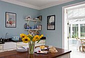 Geschnittene Sonnenblumen in der hellblauen Küche eines Hauses in Tyne & Wear, England, UK