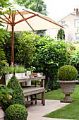 Parasol on wooden table in London garden, UK