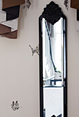 Vintage mirror and butterfly wall decor in contemporary London townhouse, England, UK