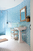 Turquoise mosaic tiled wet room with ceramic pedestal basin in Kent farmhouse England UK