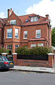 Car parked in road outside brick semi-detached London home, UK