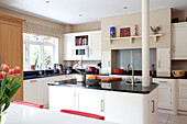 White and cream kitchen with pillar in island unit Herefordshire family home England UK
