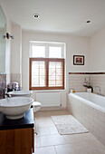 Doppelwaschbecken im cremefarben gefliesten Badezimmer eines Einfamilienhauses in Herefordshire England UK