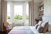 Double bed with recessed shelving in contemporary London townhouse, England, UK