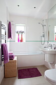 Violette Handtücher und Wäschekorb im Badezimmer eines modernen Hauses in London, England, Vereinigtes Königreich
