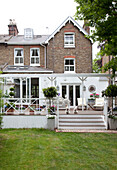 Two scottie dogs sit on raised terrace exterior of London semi-detached home, UK