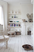 Contemporary shelving in room with bare painted floorboards, London townhouse, England, UK