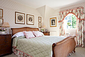 Antique wicker bed in sunlit bedroom of Sussex farmhouse, England, UK